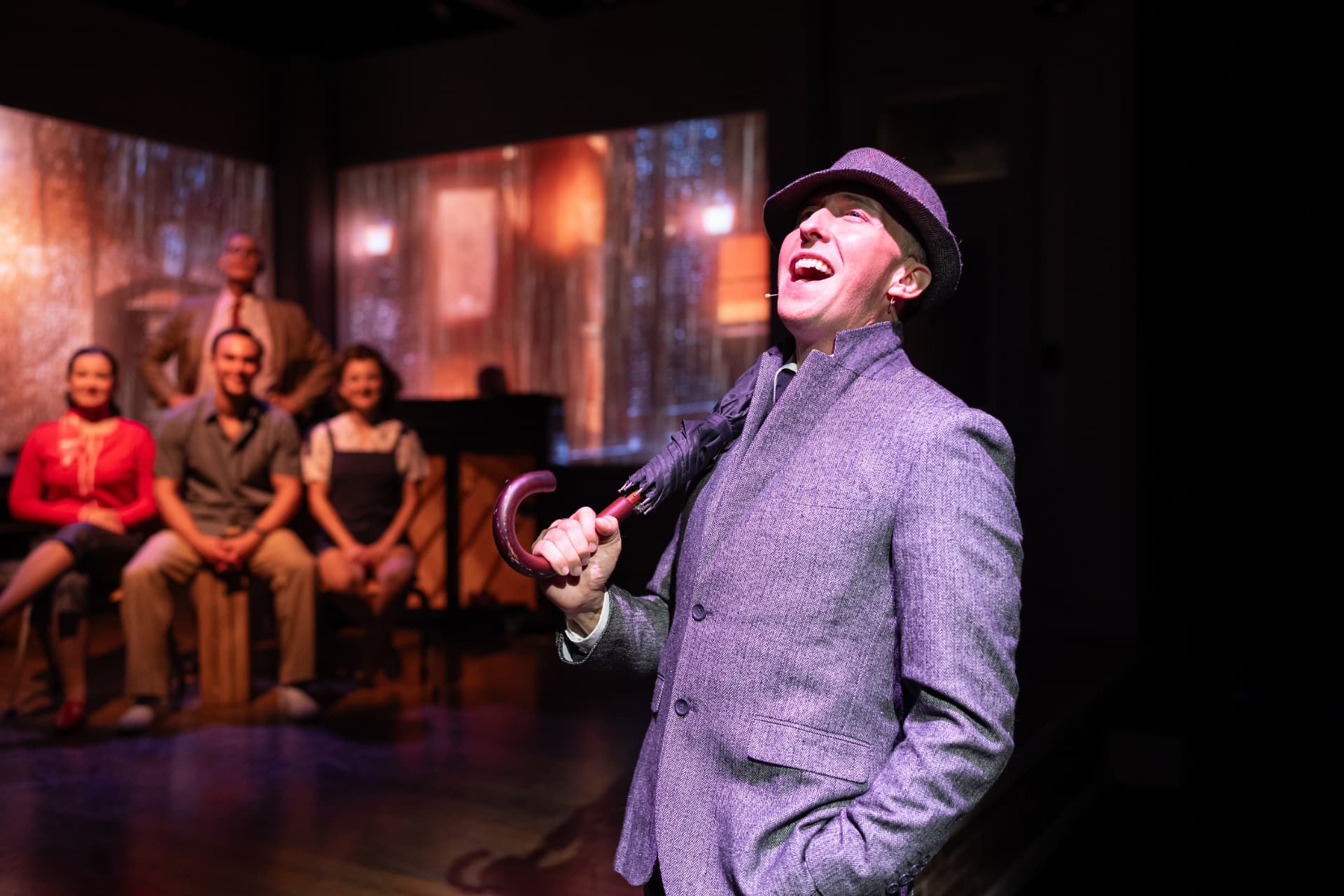 John T. Wolfe as Gene Kelly sings with an umbrella in freeFall Theatre's What a Glorious Feeling!