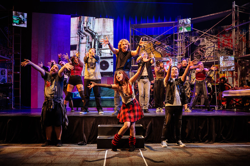 The full ensemble of Jobsite Theater's American Idiot performs a dance number on the scaffolded set.
